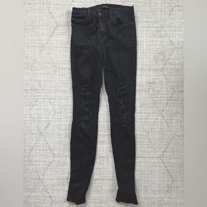 J Brand black high rise, skinny jeans. Distressed with holes up both legs.